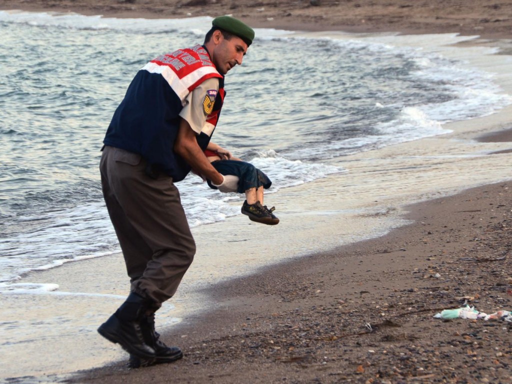 Police officer carrying Aylan Kurdi