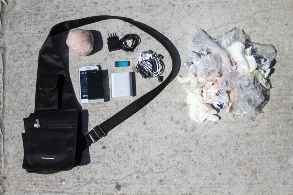 The contents of a 34-year-old refugee's bag: Anonymous, 34, from Syria “I had to leave behind my parents and sister in Turkey. I thought, if I die on this boat, at least I will die with the photos of my family near me.” Money (wrapped to protect it from water), Old phone (wet and unusable) and new smart phone, Phone chargers and headphones (plus extra battery charger), 16GB flash drive (containing family photos).