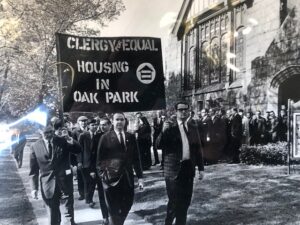 Black and white photo from 1960s showing protesters marching with banner: equal housing in oak park